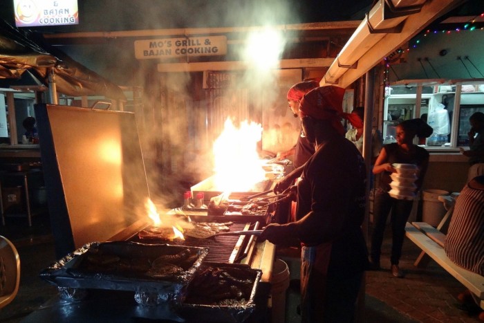 Preparing grilled fish at night fish market