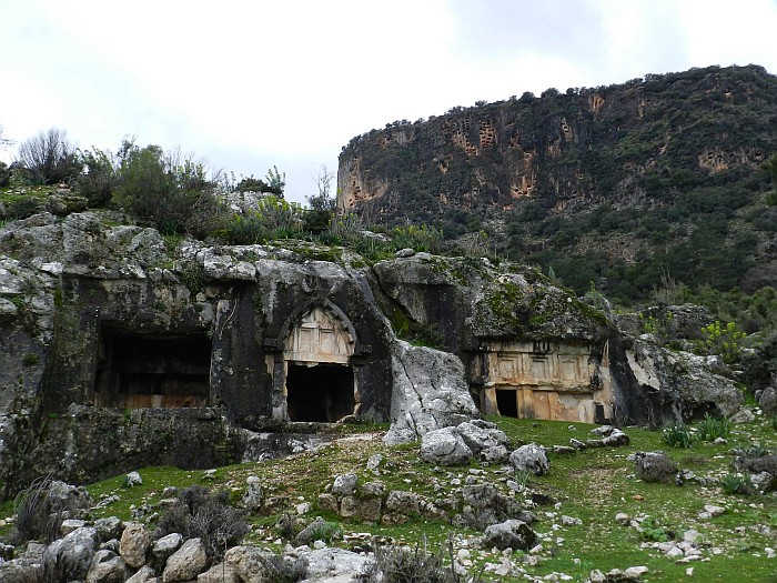 Bull-headed tomb in the front and rock tombs back on the mountain that look like pigeon-holes from far distance.