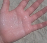 Sand of Koukounaries beach leaves shiny spots on your hand